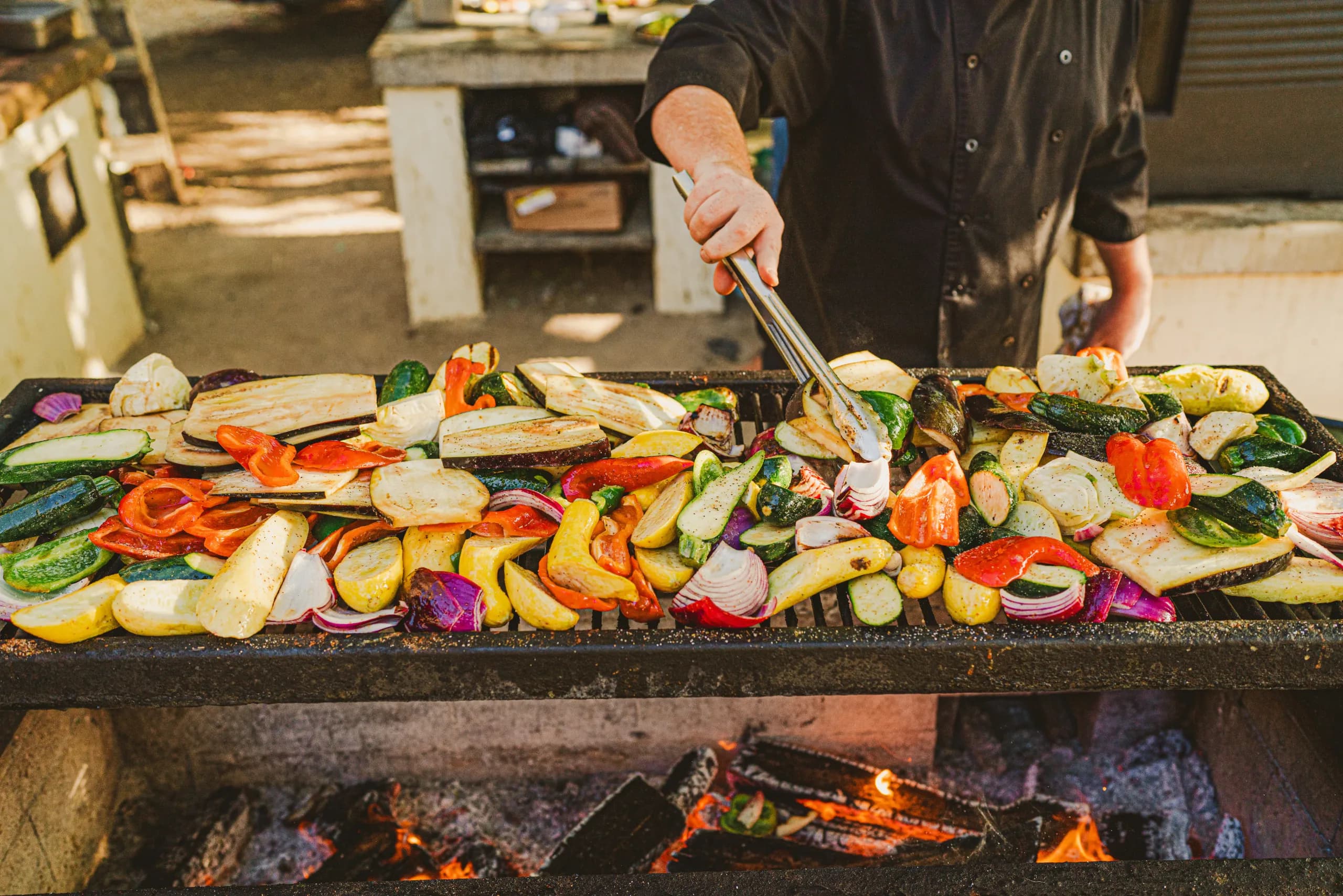 person grilling vegetables