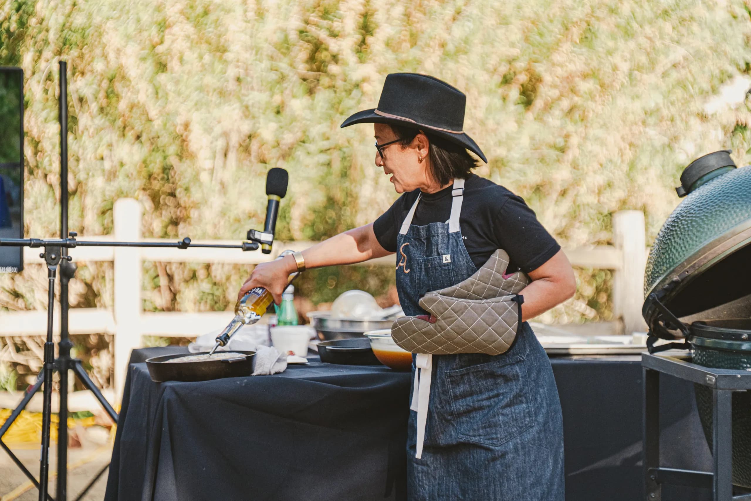 person pouring liquid into cast iron pan