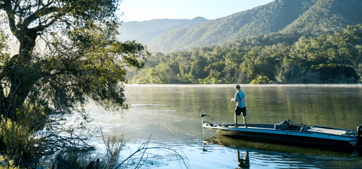person standing on a boat fishing