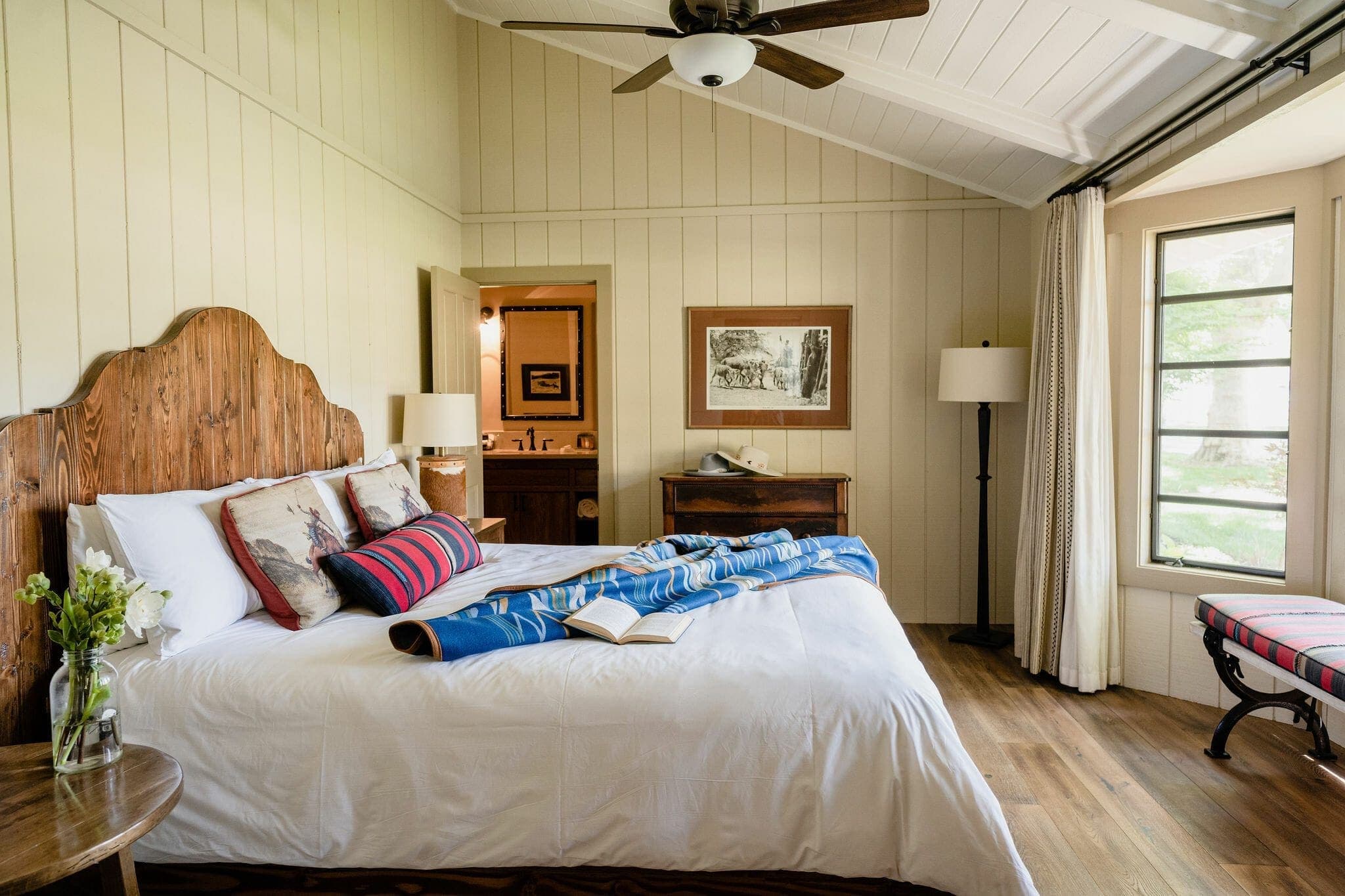 queen bed with side tables and door to bathroom inside the Sycamore house