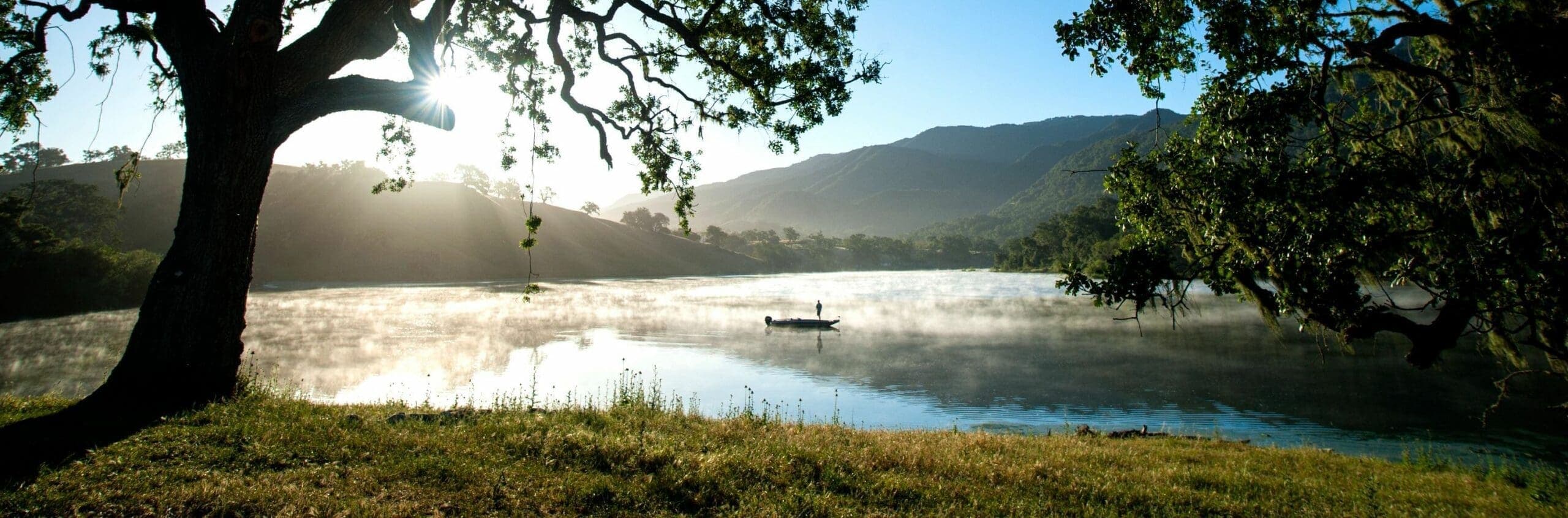 view of person standing on boat in the middle of the lake