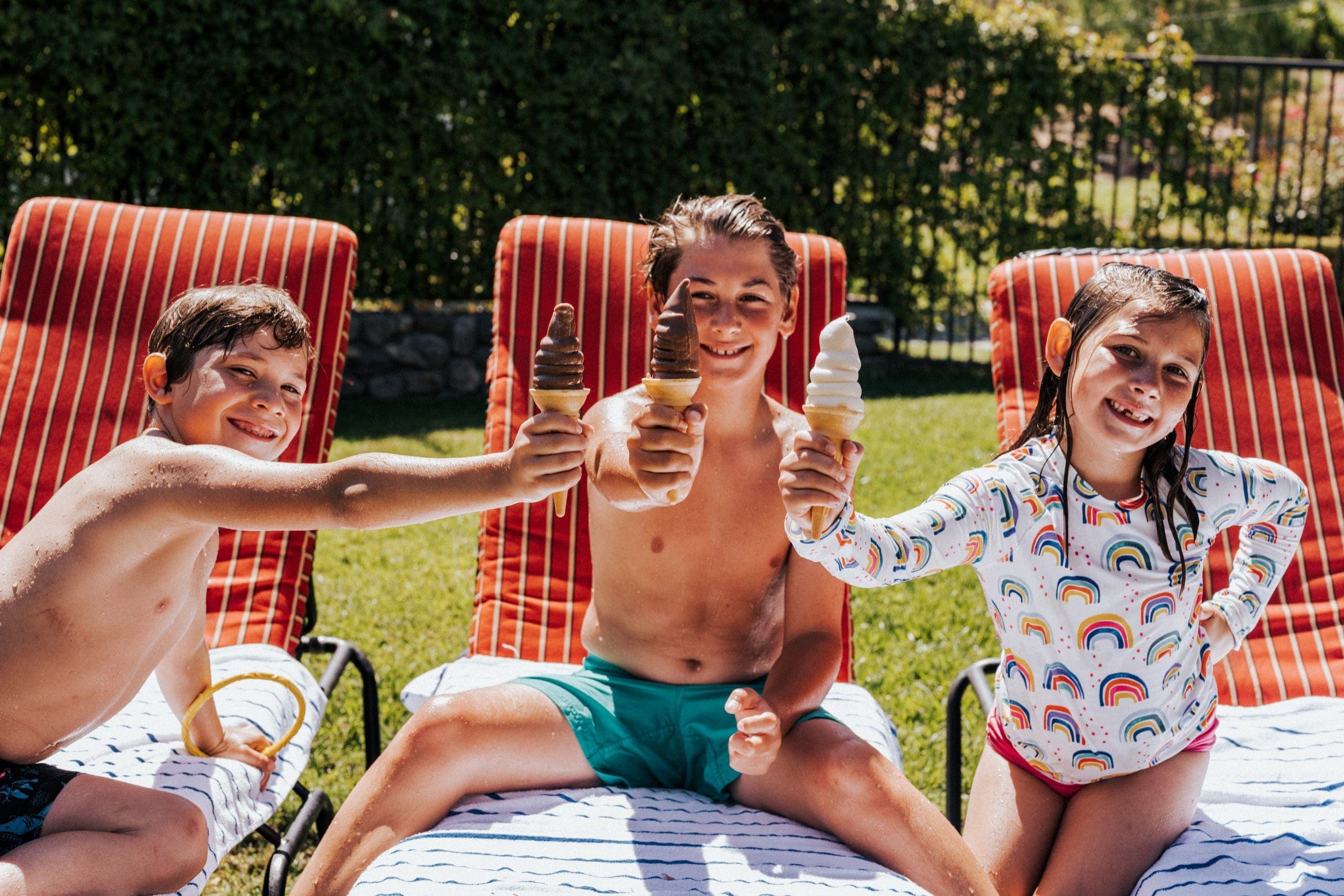 three kids smiling while holding their ice cream