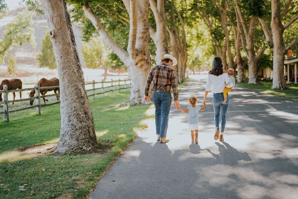 Family walking away down a tree lined walkway at Alisal Ranch