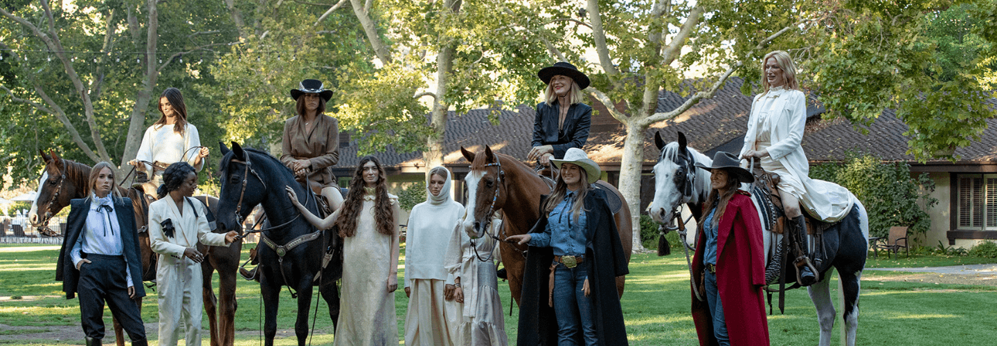 group of people standing and some people on horses wearing Designer Heidi Merrick's RNCH Collection