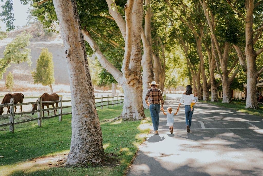 family walking with their kids outside beside the horses