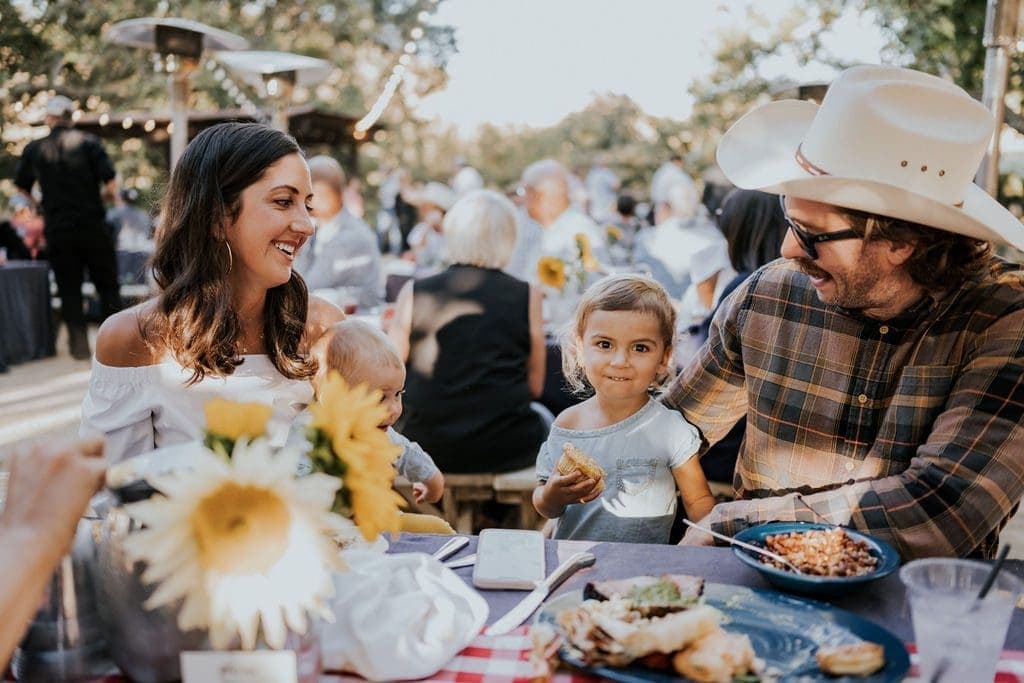 two adults and two children sitting at a table laughing at Rodeo BBQ