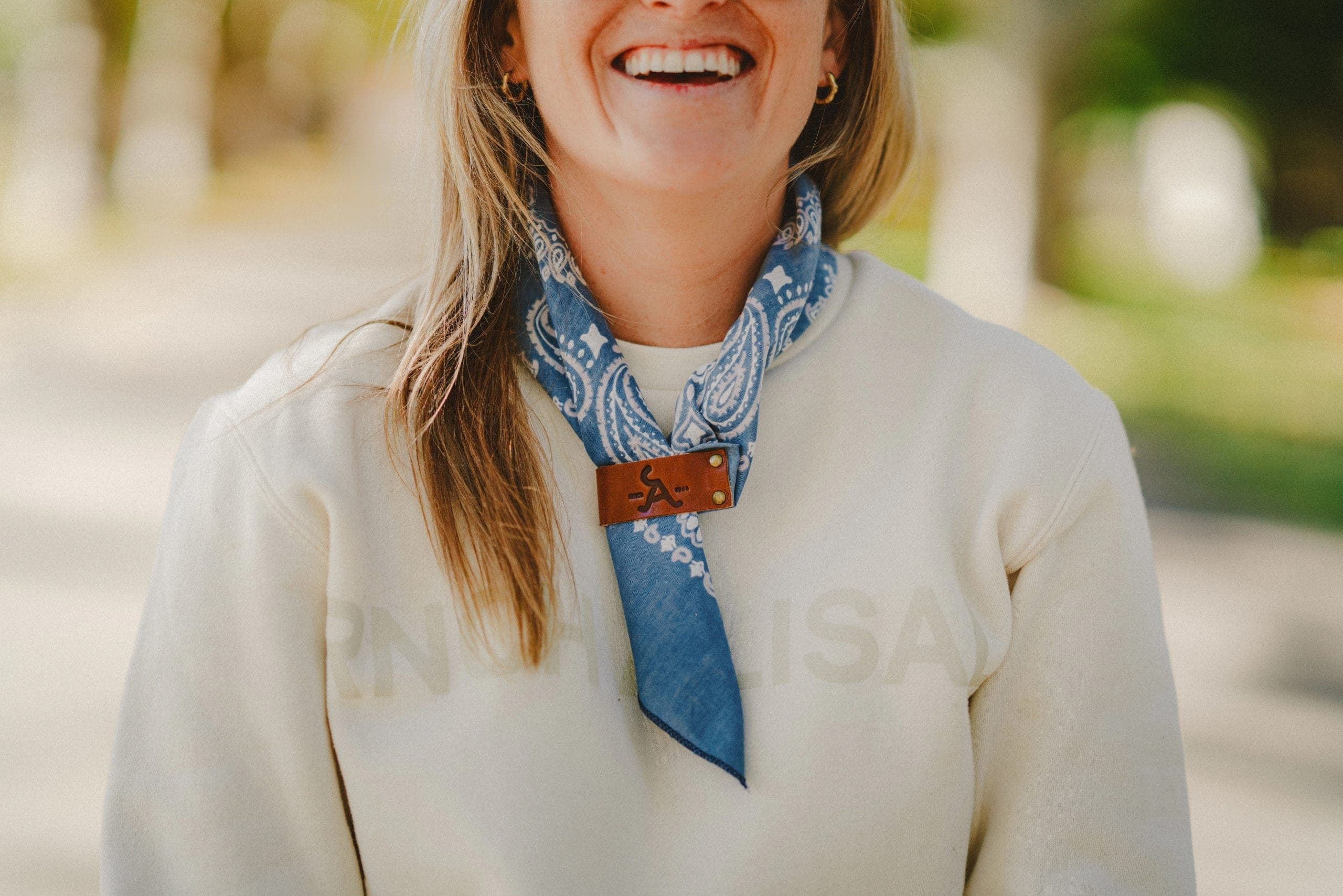 person wearing scarf on neck with alisal leather clip