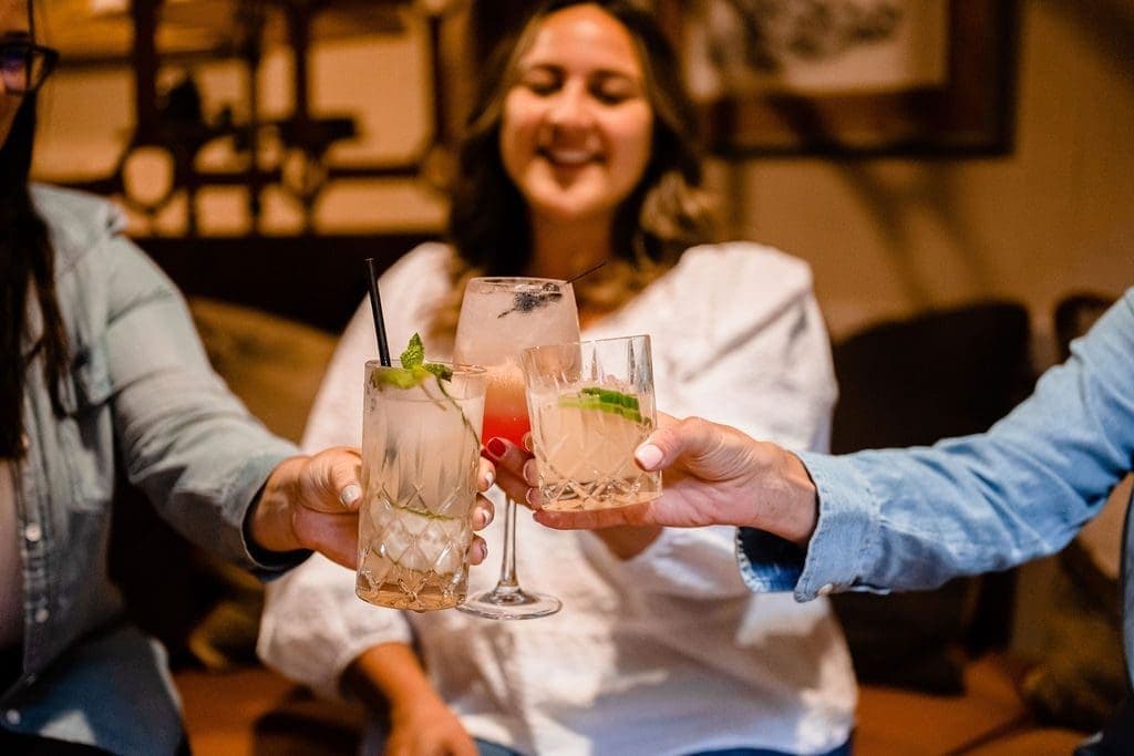 three people cheersing their drink
