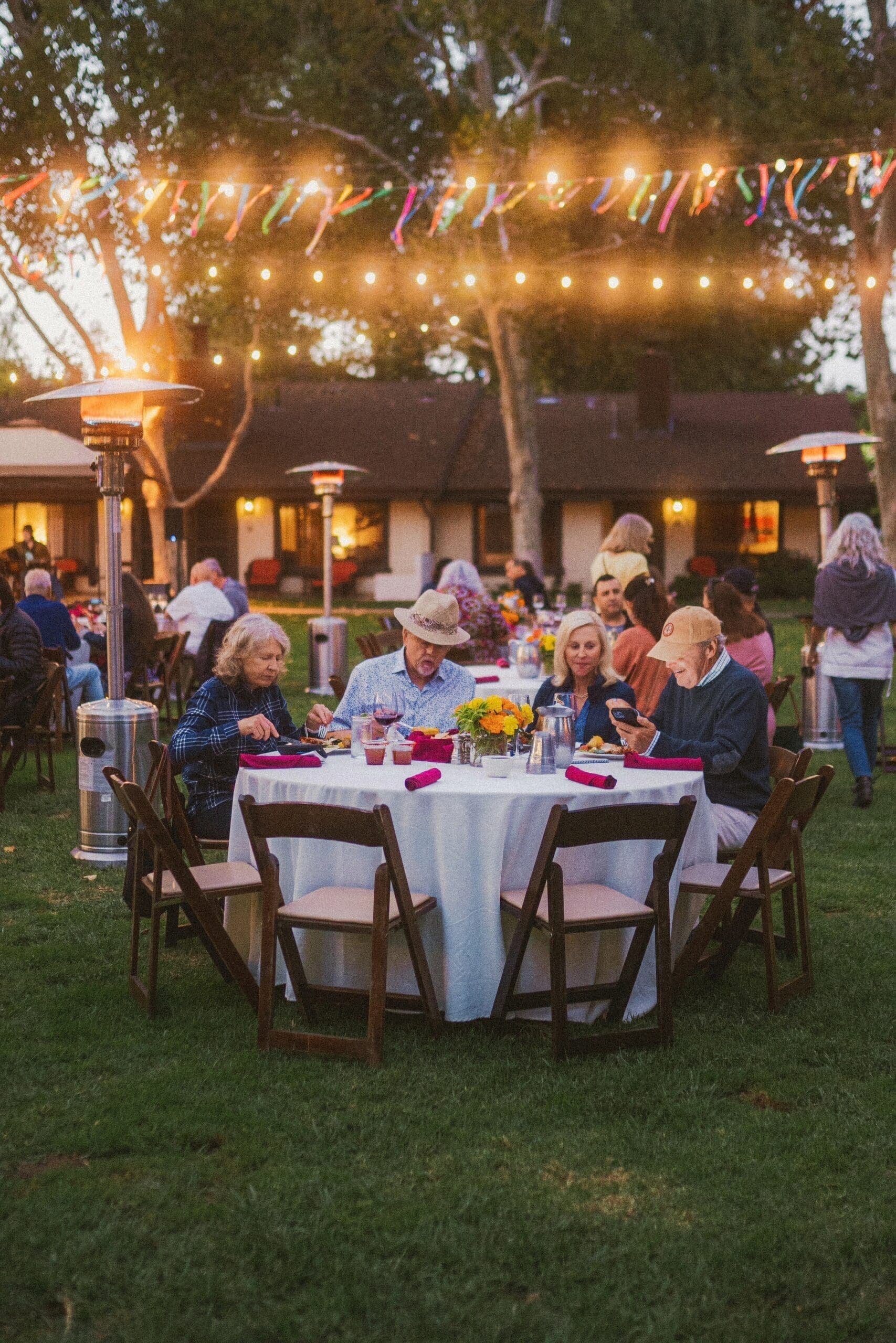 group of people sitting at an outdoor dining area eatting