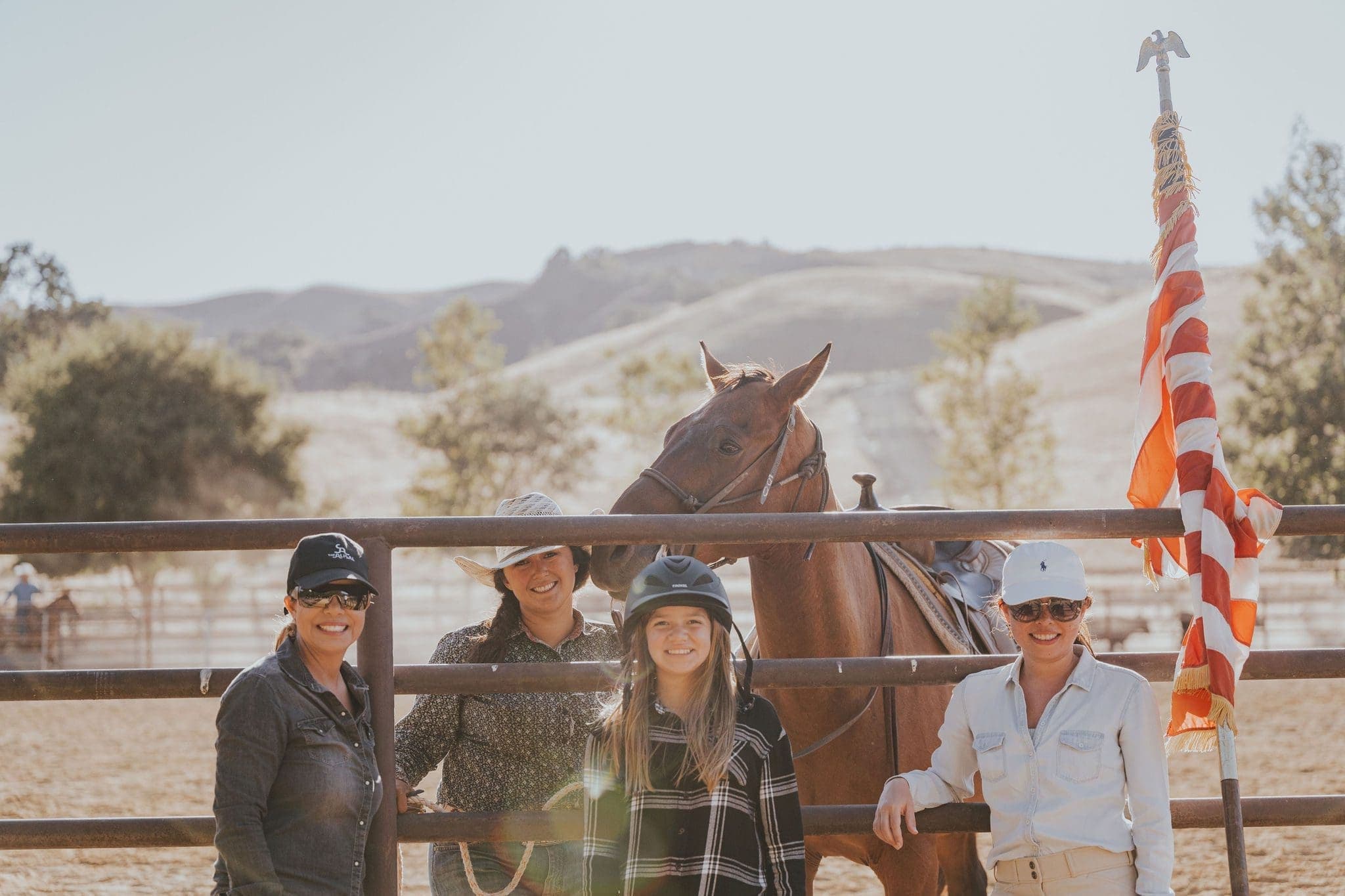 4 women posing with a horse