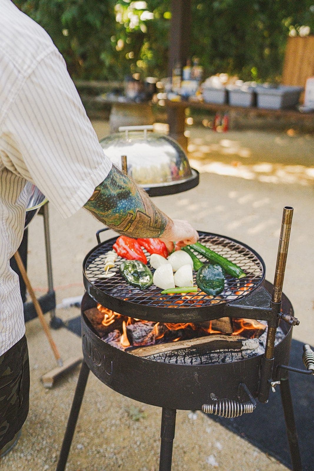 person placing vegetables on a bbq