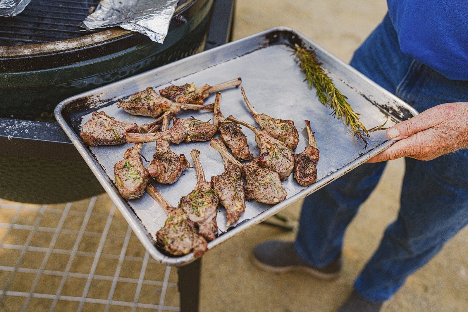 person holding bbq lamb chops in a pan