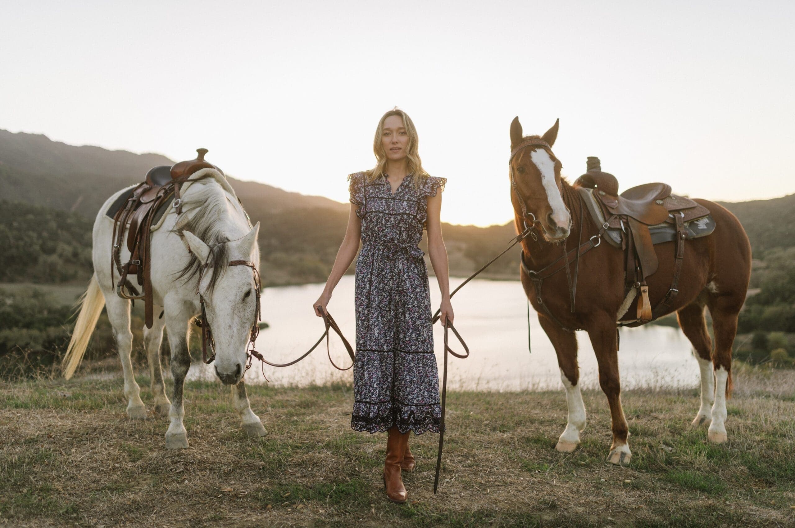 woman holding reign of two horses