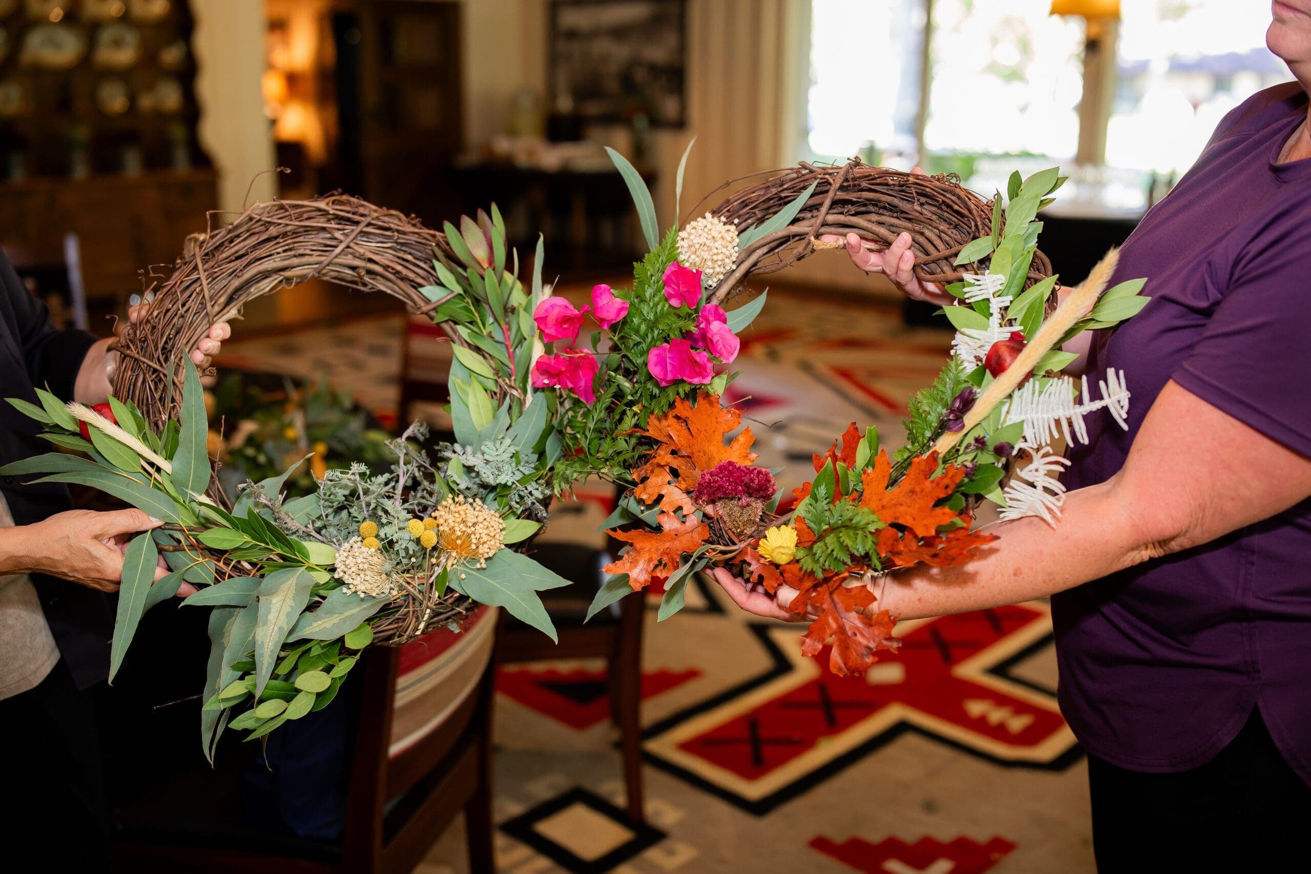 two people holding their floral wreaths