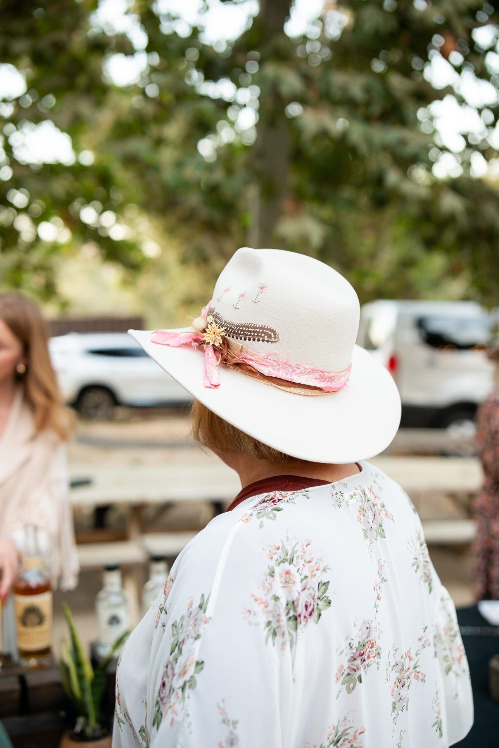 person wearing floral shirt and cowgirl hat