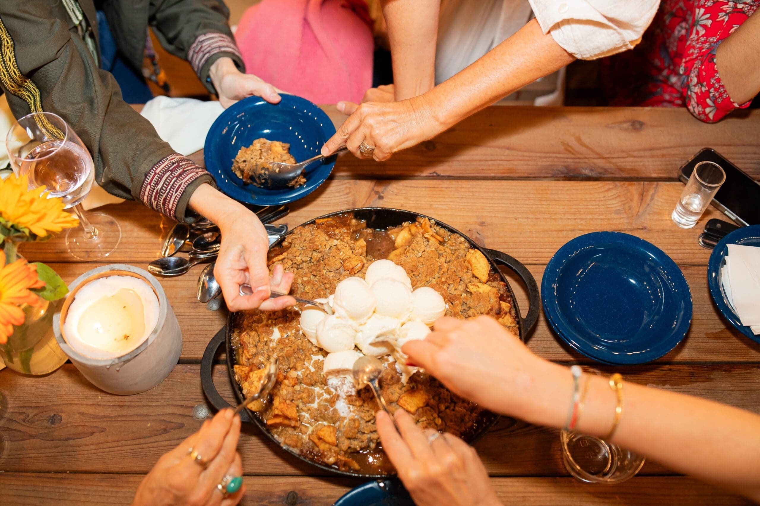 group of people grabbing food from a pot