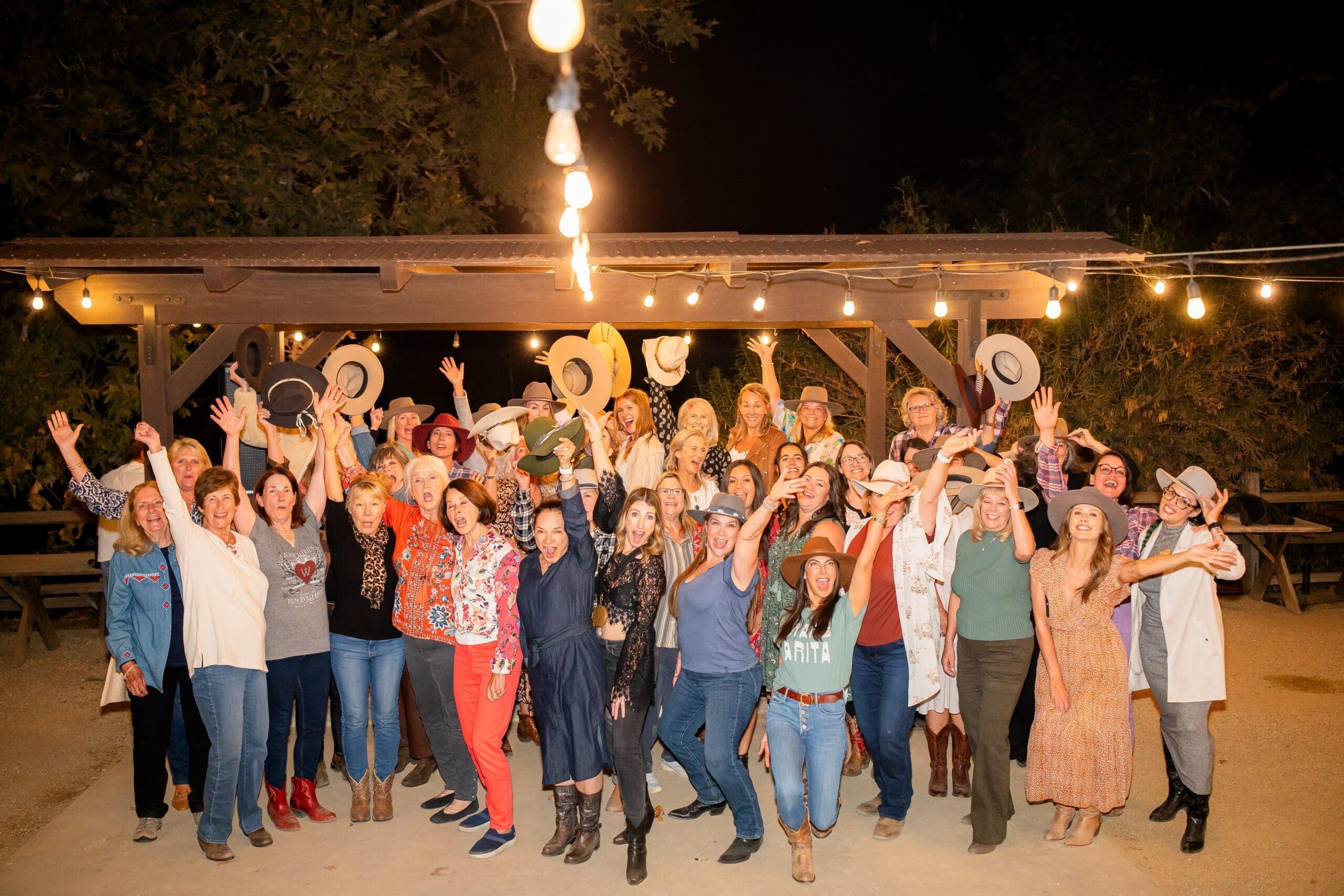 group of people smiling and posing for photo with arms in the air