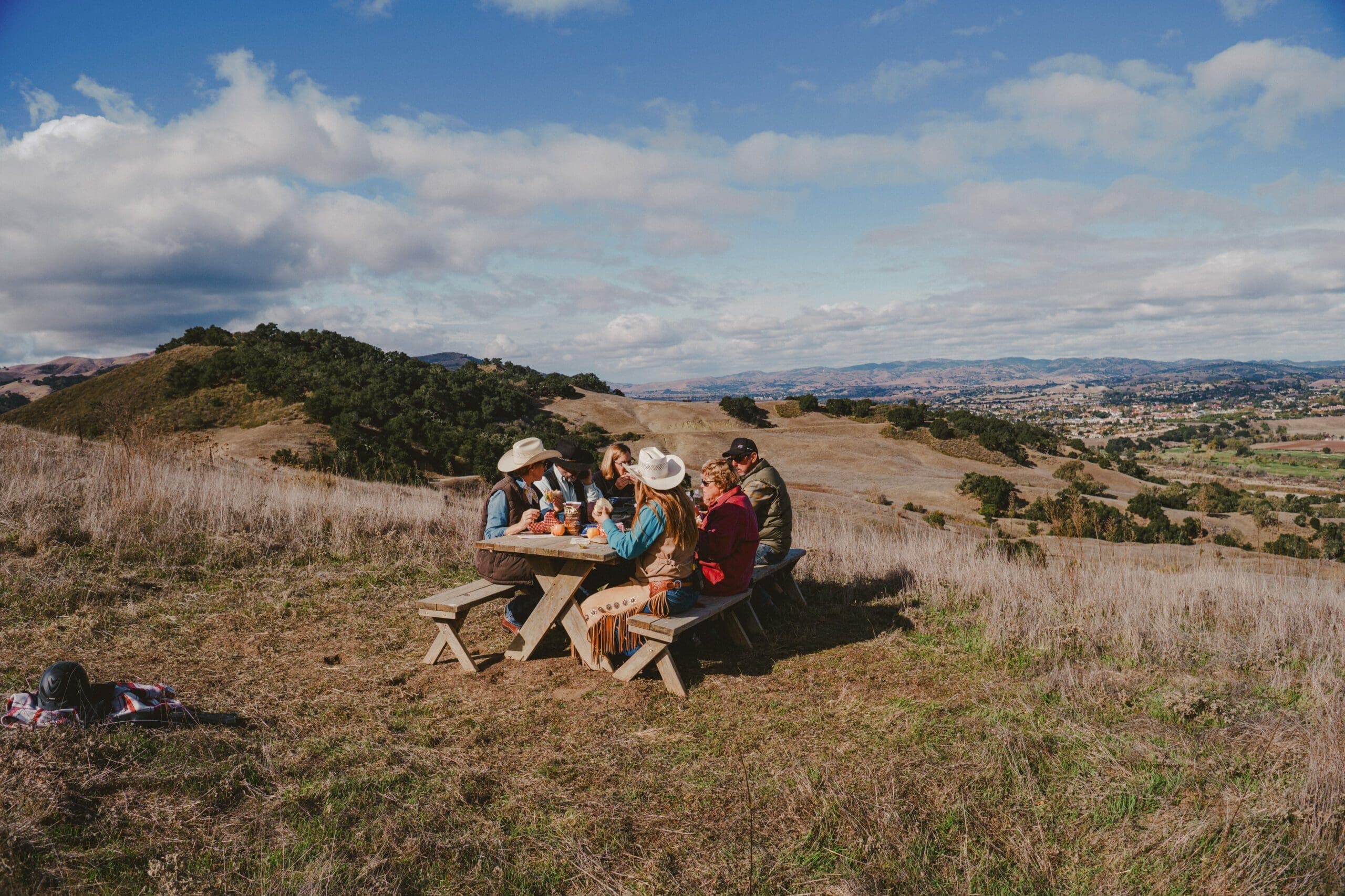 group of people eating on a picnic bench