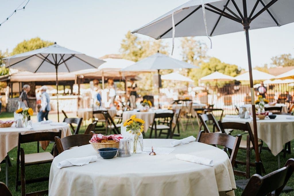 outdoor dining area with round tables and umbrellas