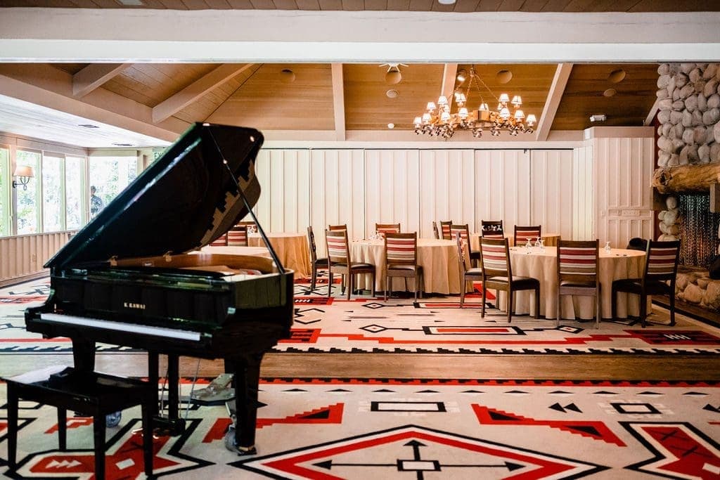 grand piano close to round tables and chairs