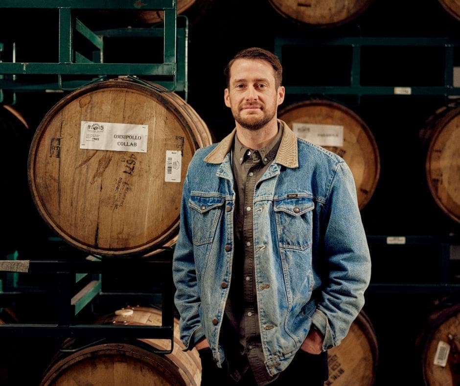 head shot of Nick Firestone beside barrels