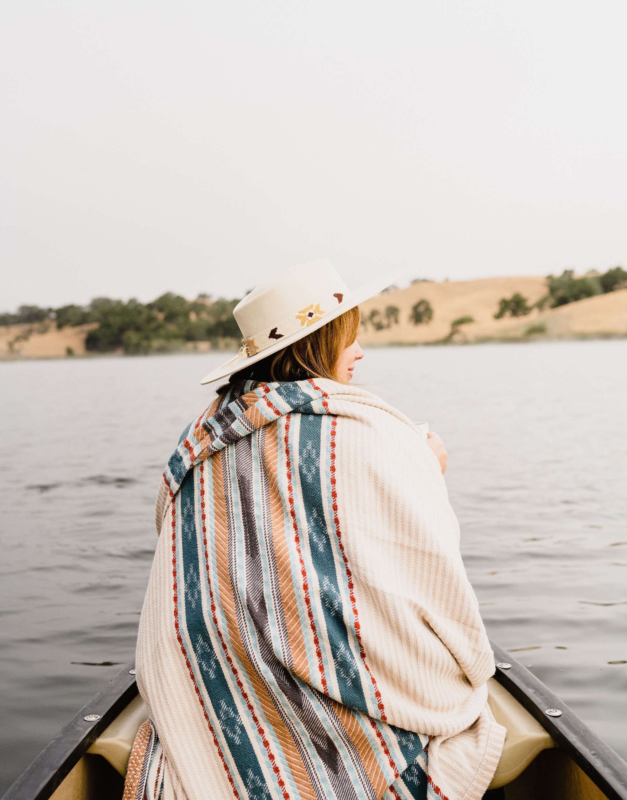 person cozy under blanket on canoe on Alisal Creek
