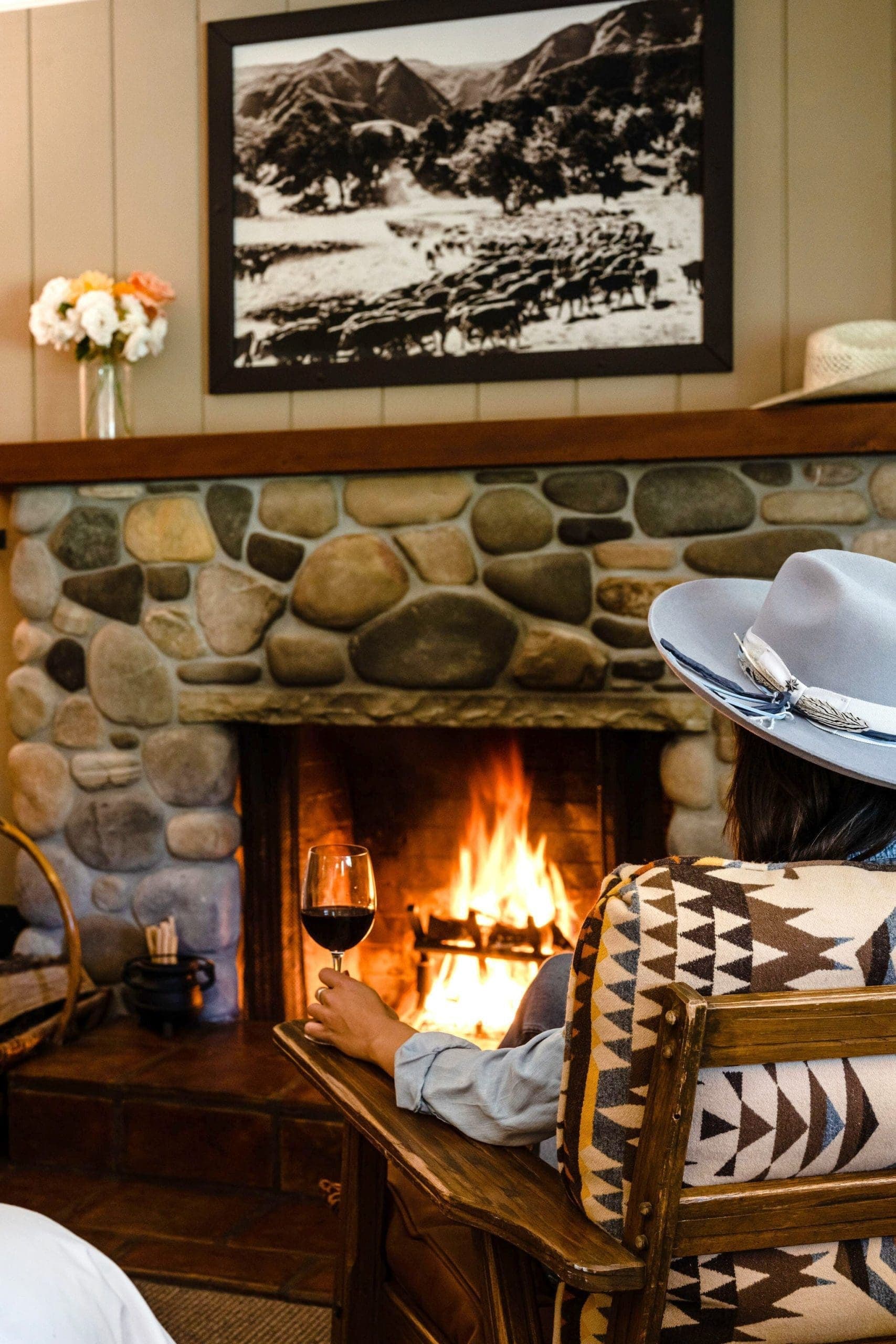 person sitting by the fire with a glass of wine