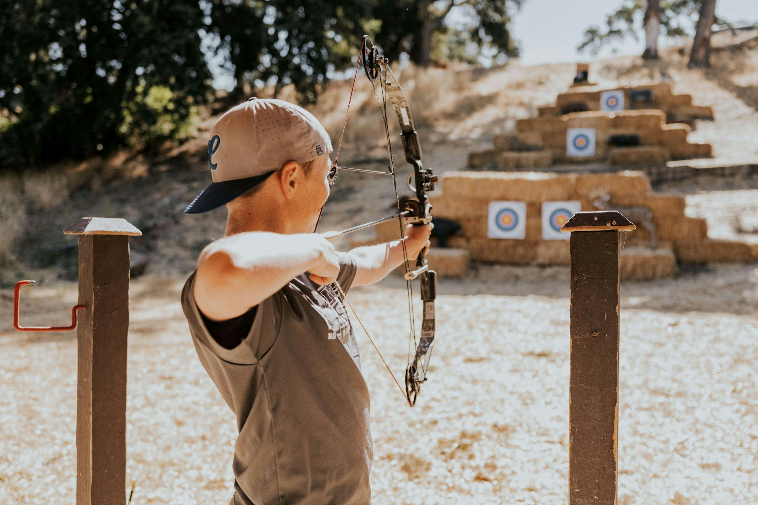 person pointing an arrow and bow at a target