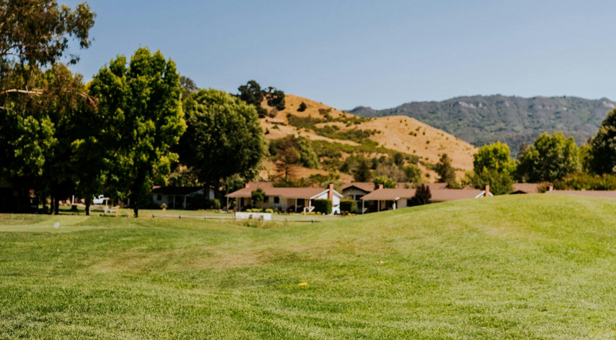 golf ranch course with view of ranch and hills