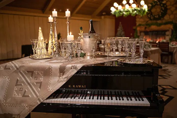 grand piano with champagne glasses and wine bottoms on top
