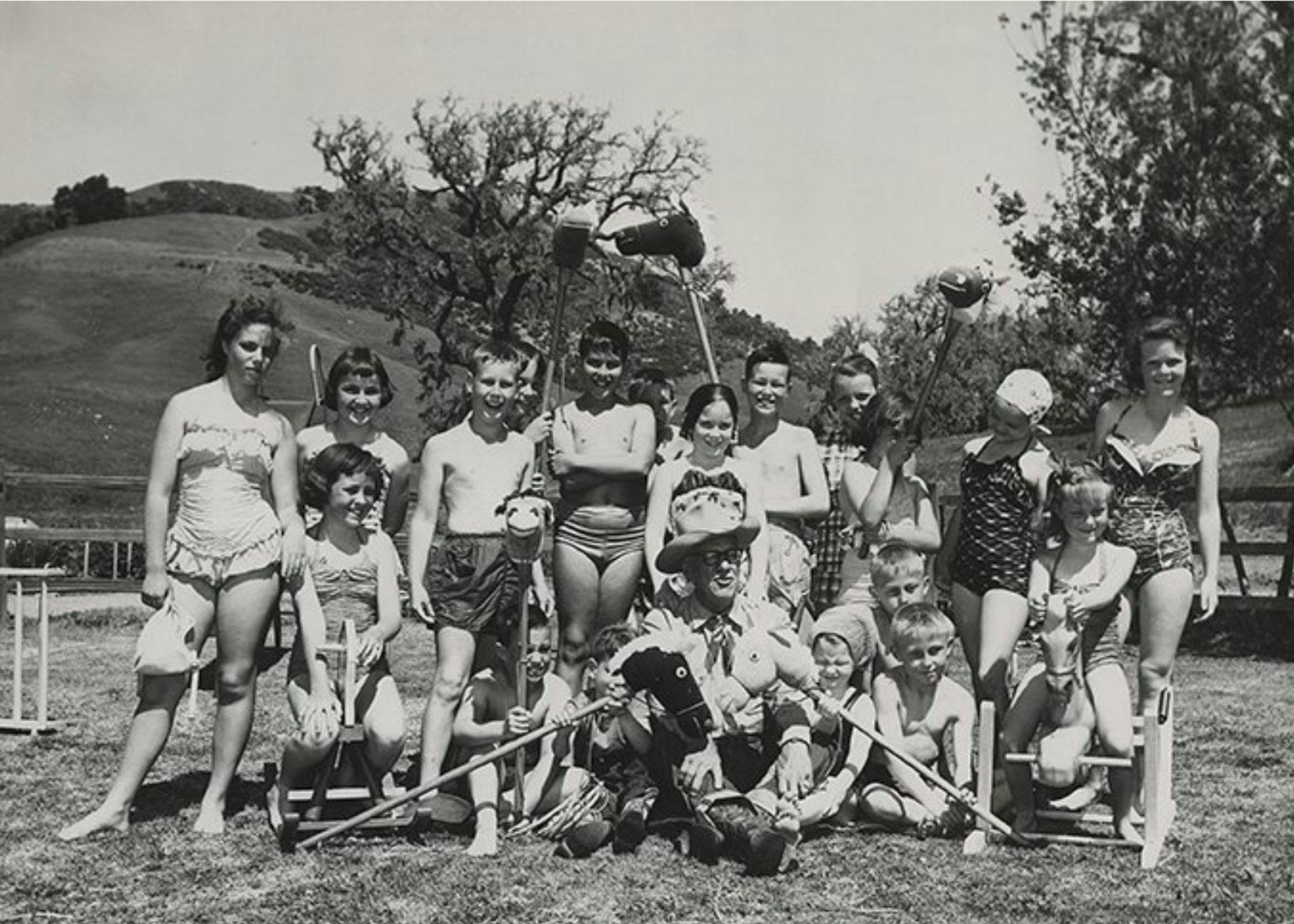 historic photo of people and kids in posing with stick horses