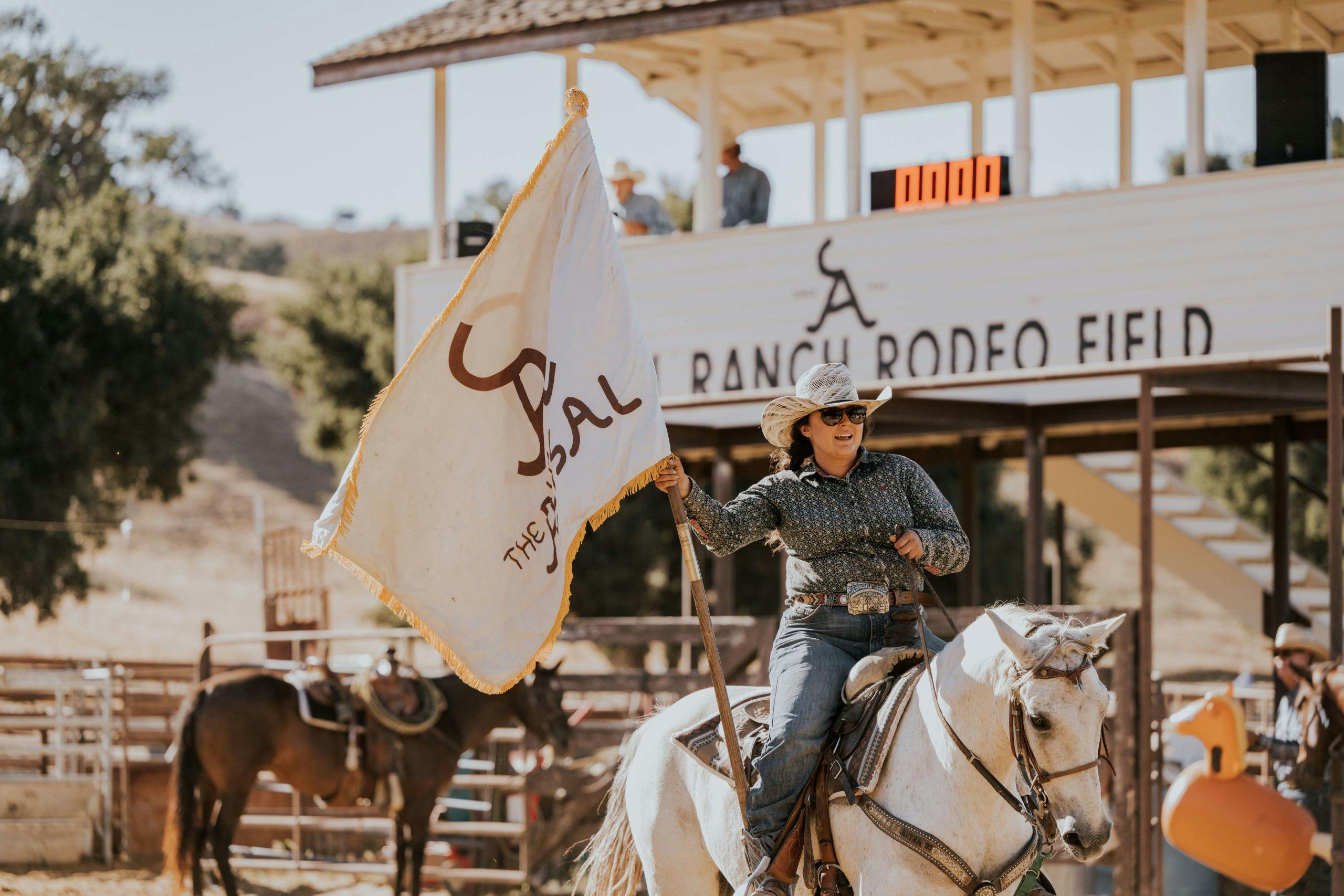 person riding horse holding The Alisal Flag