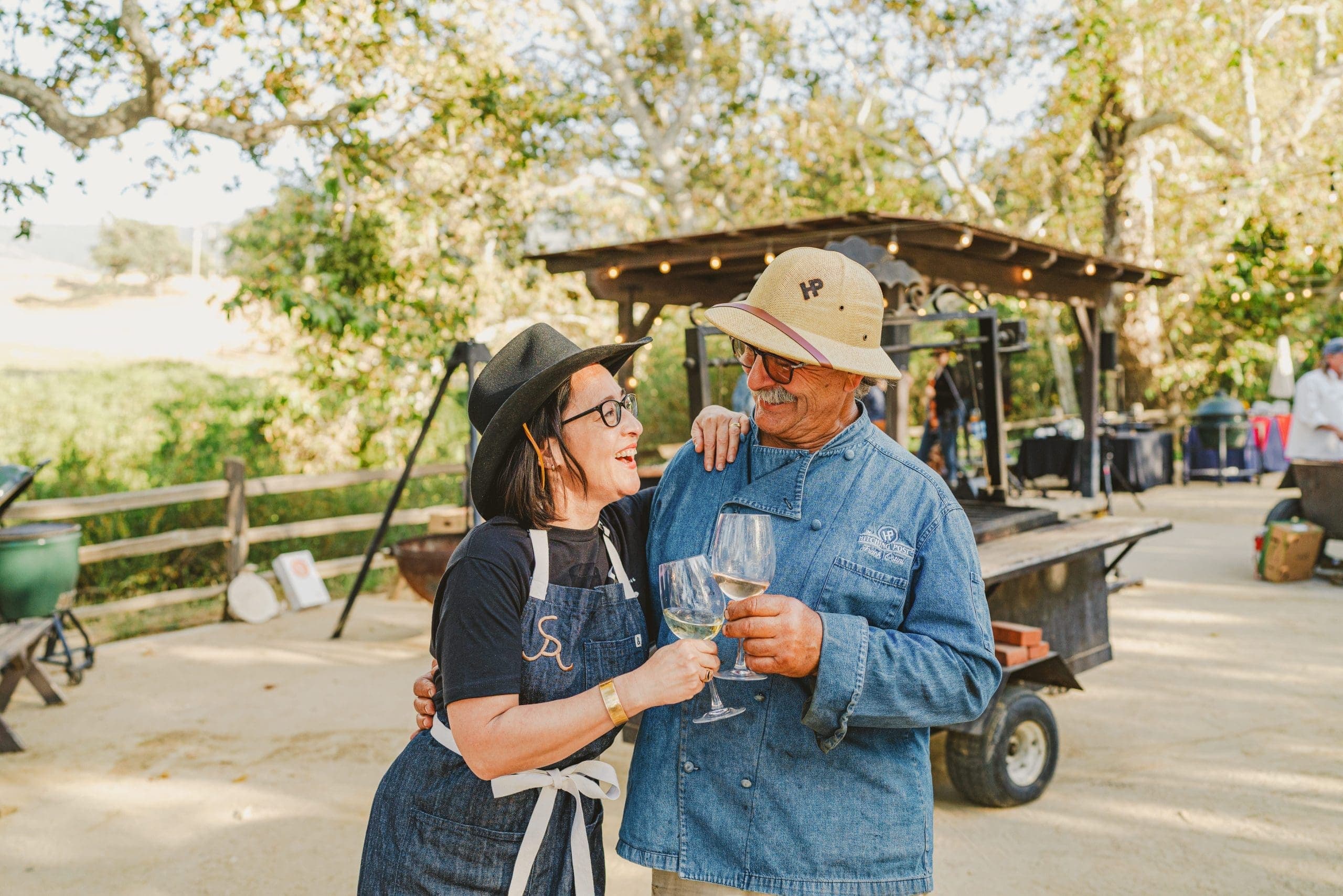 two people smiling at each other toasting a glass of wine