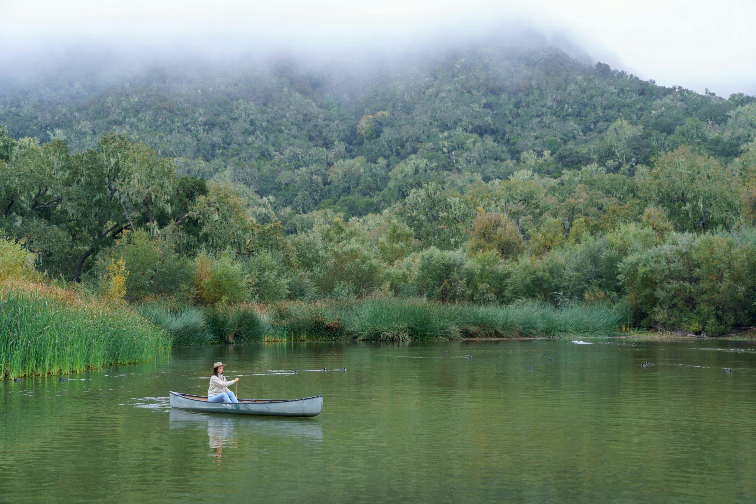 person canoeing on the lake