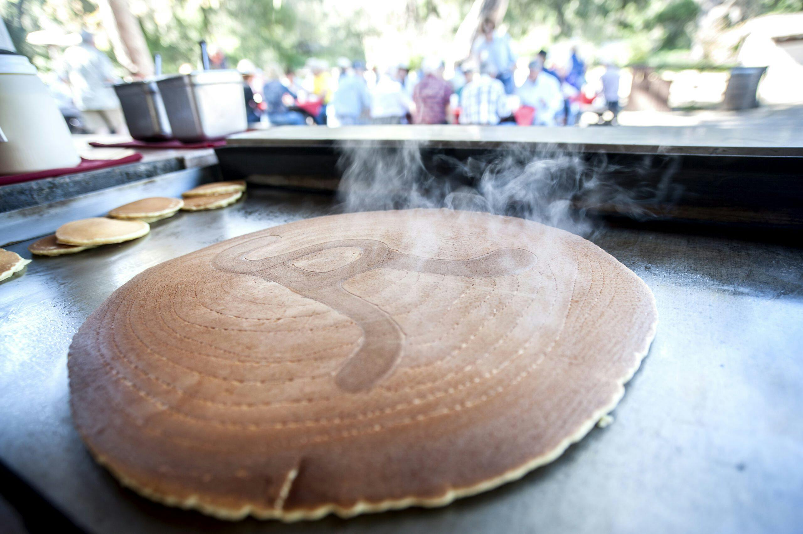 pancakes being grilled with the Alisal Logo imprinted on top
