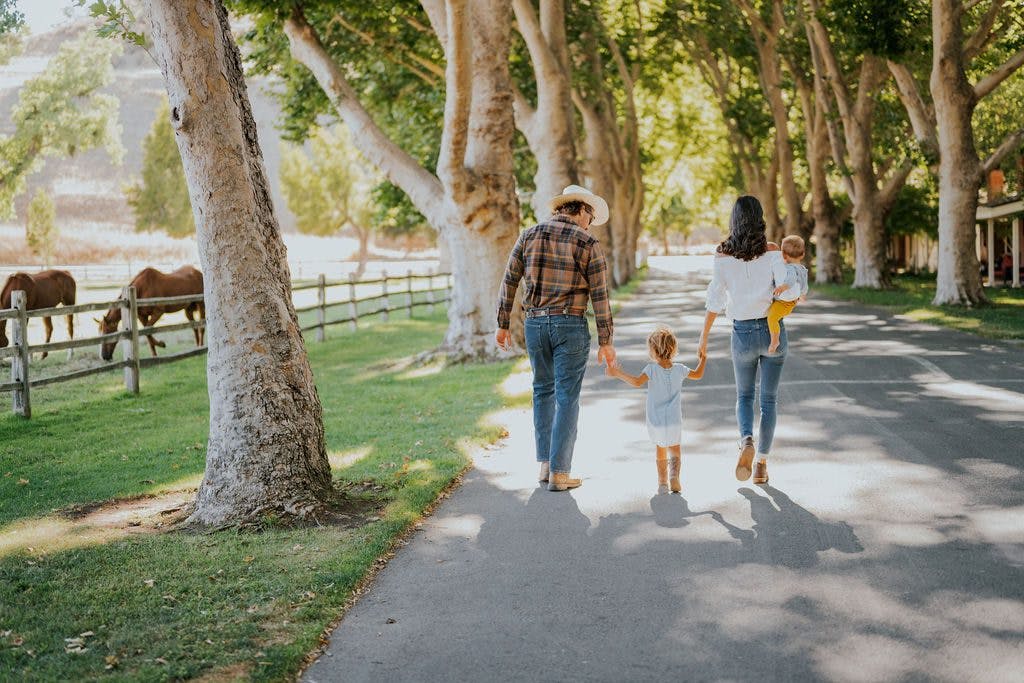 Family walking away down a tree lined walkway at Alisal Ranch