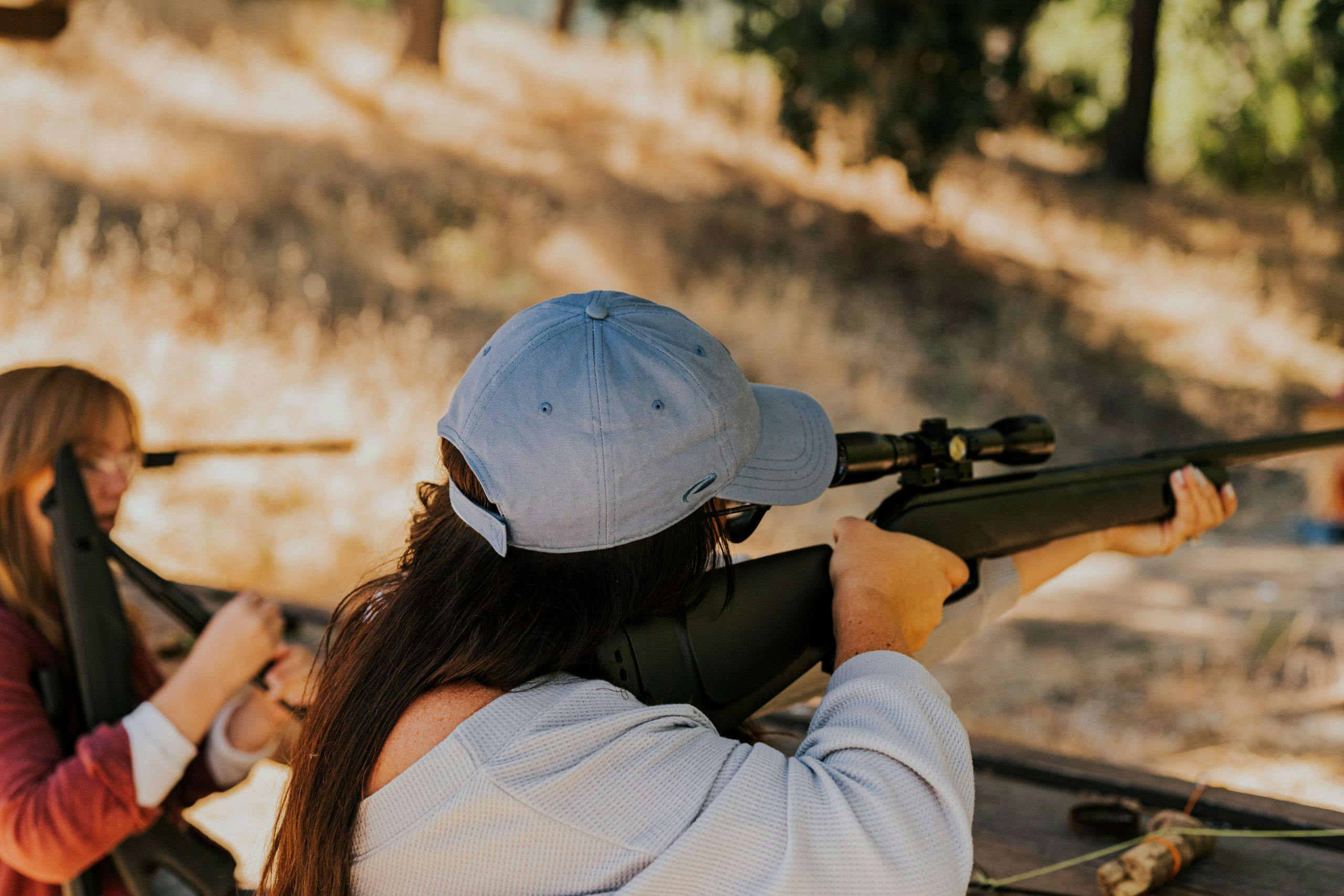 person pointing an air rifle at a target