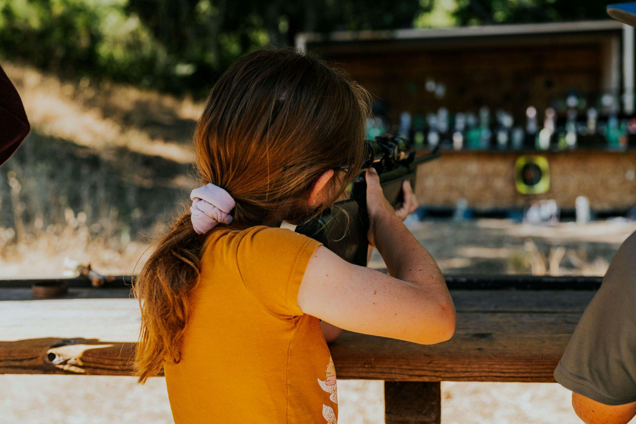 young person pointing an air rifle at a target